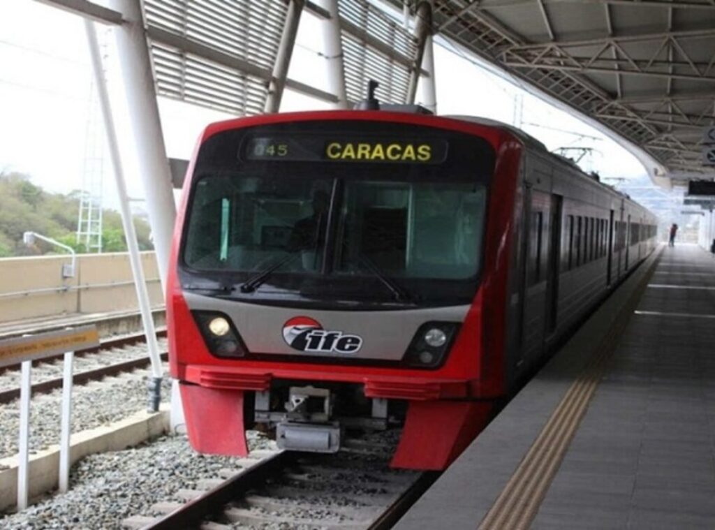 Tren rojo del IFE del ferrocarril Caracas en una estación, con destino Caracas en el letrero
