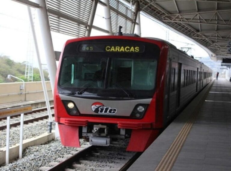 Tren rojo del IFE del ferrocarril Caracas en una estación, con destino Caracas en el letrero