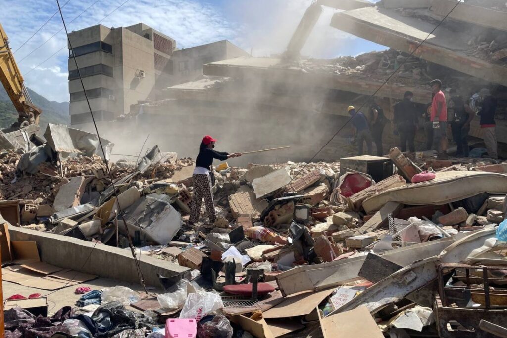 Escombros de un edificio derrumbado por los terremotos en La Guaira, en la zona de Residencias Caribe, con rescatistas y vecinos entre los restos