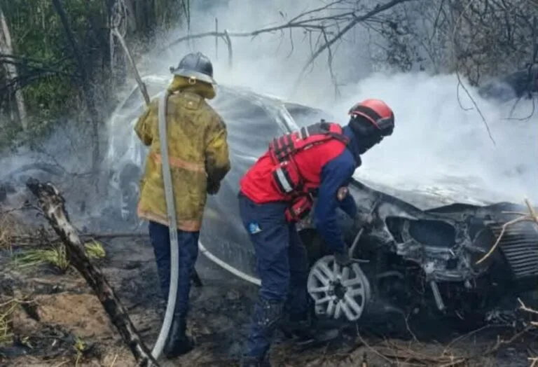 Bomberos y rescatistas trabajan junto a la camioneta calcinada que cayó a un barranco en la vía Tacarigua-La Laguna, en Río Chico, Miranda: nieto de Hugo Chávez herido