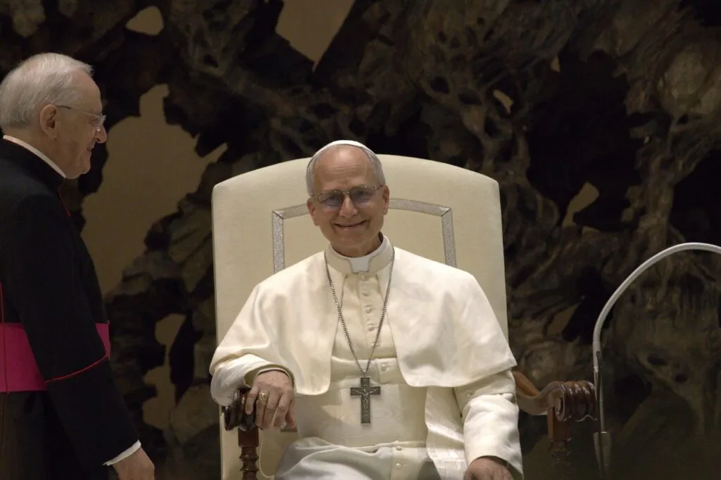 León XIV víctimas de abusos: el papa, de blanco y sonriente, sentado durante una audiencia en el Vaticano