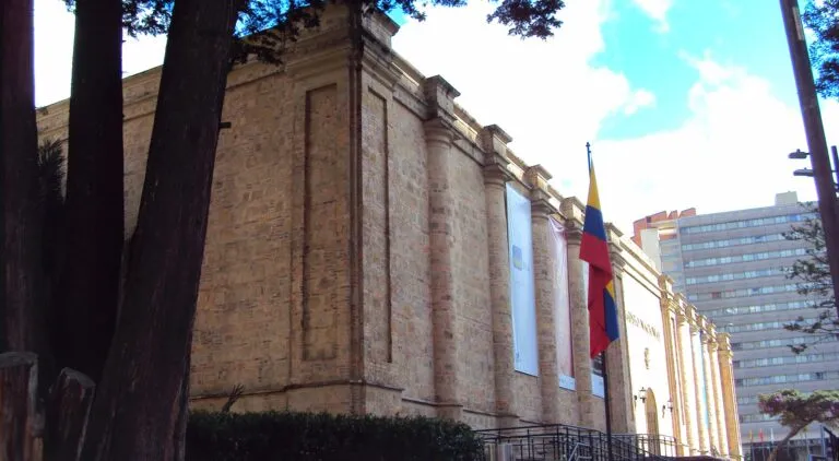 Piezas retiradas del Museo Nacional: fachada de piedra del Museo Nacional de Colombia en Bogotá con la bandera de Colombia