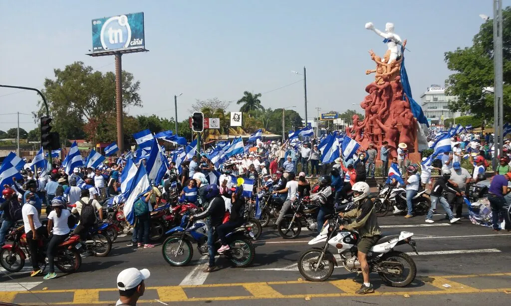 Presos políticos en Nicaragua: manifestantes con banderas nicaragüenses durante una protesta en Managua