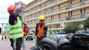 Obreros de la construcción cargan materiales de las obras de recuperación ligadas a la producción de cemento en Venezuela