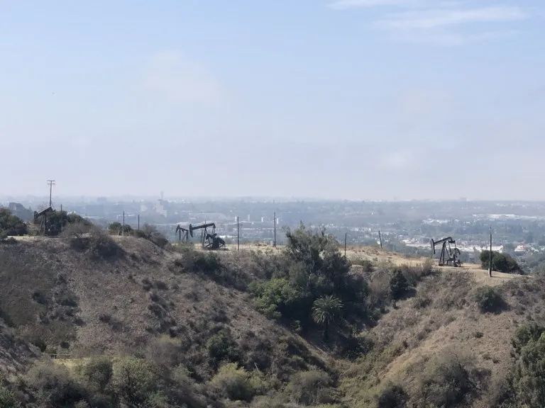Producción de petróleo en Los Ángeles: balancines del campo petrolero de Inglewood con la ciudad al fondo