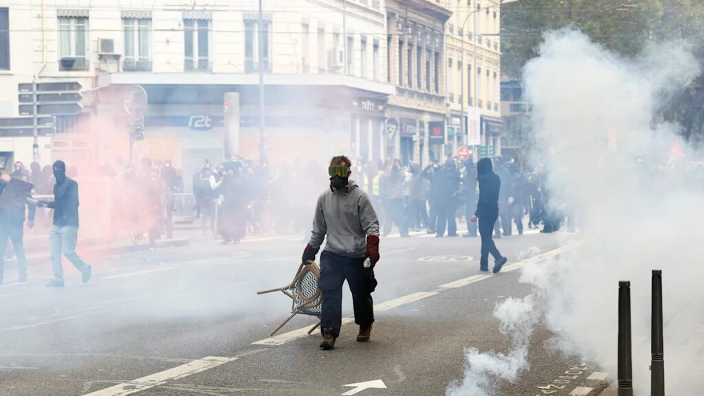 Protestas en Francia dejan 135 detenidos: un manifestante con máscara antigás en medio de gases lacrimógenos en Lyon