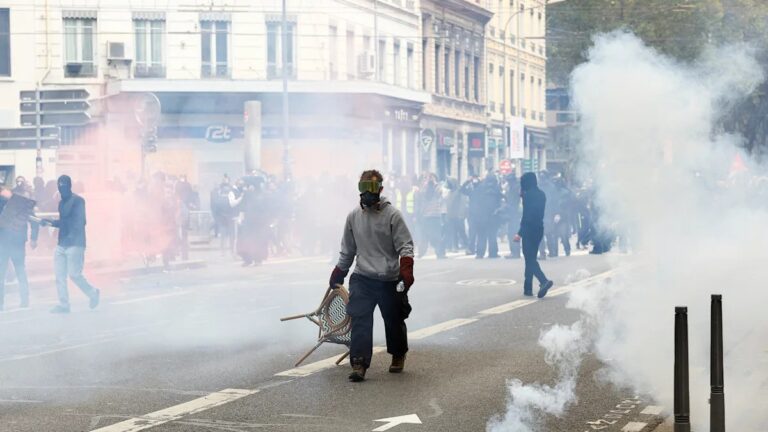 Protestas en Francia dejan 135 detenidos: un manifestante con máscara antigás en medio de gases lacrimógenos en Lyon