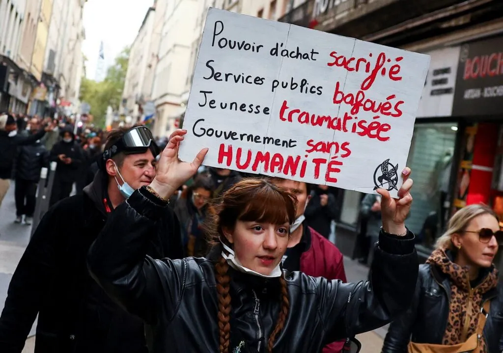 Protestas en Francia: una joven manifestante levanta una pancarta contra el Gobierno durante una marcha estudiantil