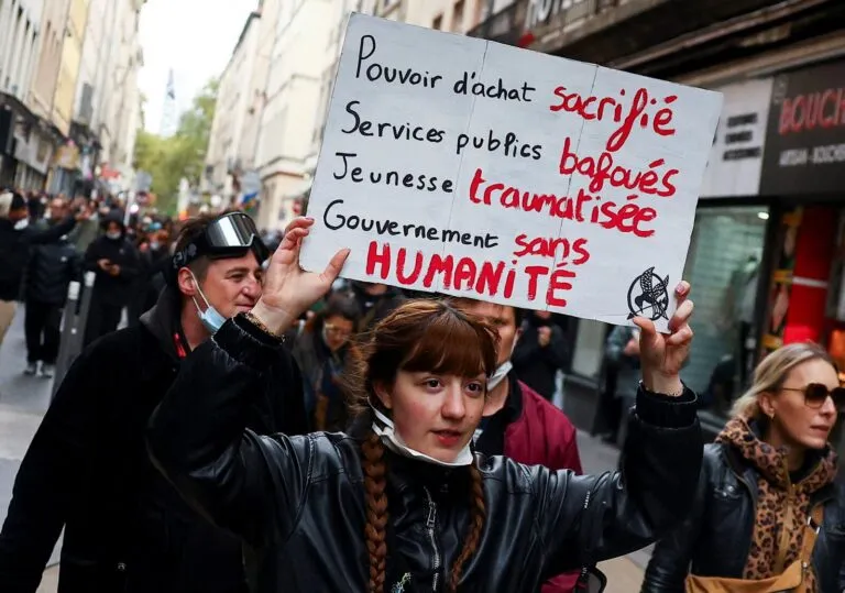 Protestas en Francia: una joven manifestante levanta una pancarta contra el Gobierno durante una marcha estudiantil