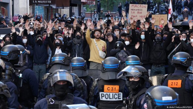 Protestas en Francia: jóvenes manifestantes con las manos en alto frente a agentes de policía en una calle de París
