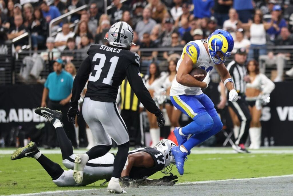 Rams vencen a los Raiders en Las Vegas: Puka Nacua con el balón evade a la defensiva de los Raiders en el Allegiant Stadium