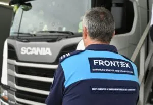 Reforma de Frontex: un agente de la agencia europea de fronteras, de espaldas, frente a un camión durante un control