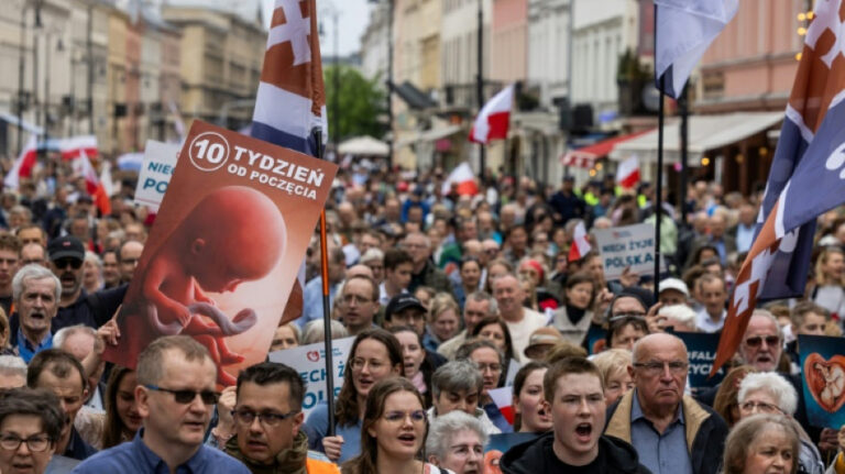 Marcha contra el aborto en Polonia: manifestantes con banderas polacas y un cartel provida durante una protesta en el país europeo, en el debate por la reforma del aborto en Polonia