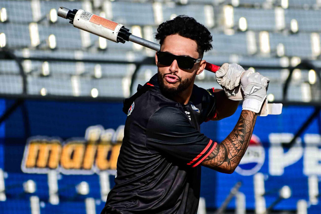 Resultados de la LVBP: Samuel Zavala, jardinero de los Cardenales de Lara, durante una práctica de bateo con bate con peso y el uniforme de entrenamiento de su equipo
