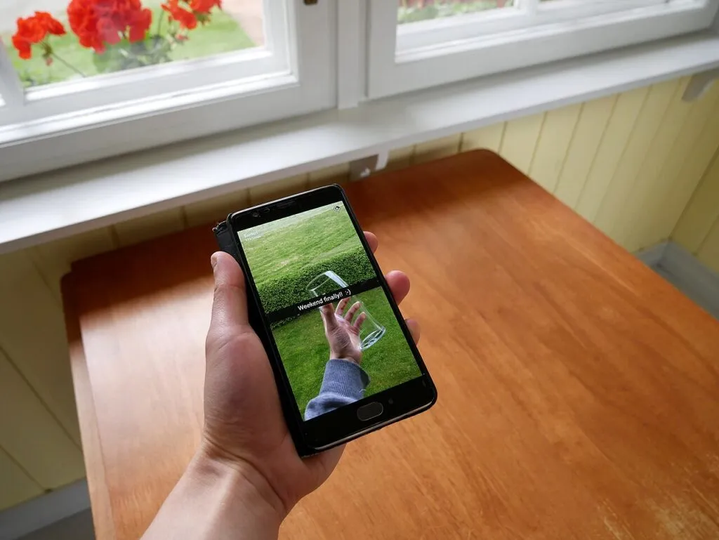 Una mano sostiene un teléfono con la aplicación Snapchat abierta; Snapchat va a juicio en Estados Unidos