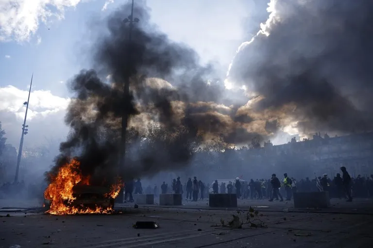 Automóvil en llamas en la plaza de la República de París durante las protestas del 17 de octubre, en una de las dos zonas con toque de queda en París