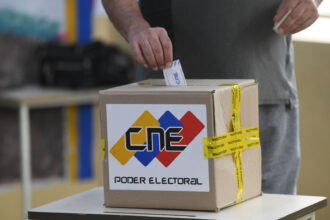 Elector depositando su voto en una urna del CNE, símbolo de la transición democrática en Venezuela