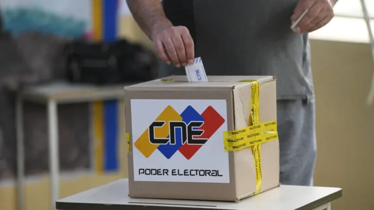 Elector depositando su voto en una urna del CNE, símbolo de la transición democrática en Venezuela