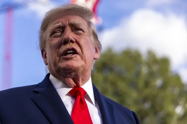 El presidente Donald Trump habla durante un acto al aire libre con una bandera de Estados Unidos al fondo: Trump en Kentucky