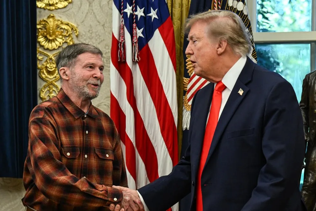 Donald Trump estrecha la mano de Stephen Hubbard en el Despacho Oval durante el acto en que Trump recibe a Stephen Hubbard tras su liberación de Rusia