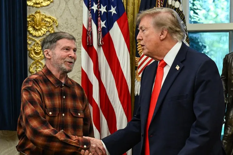 Donald Trump estrecha la mano de Stephen Hubbard en el Despacho Oval durante el acto en que Trump recibe a Stephen Hubbard tras su liberación de Rusia