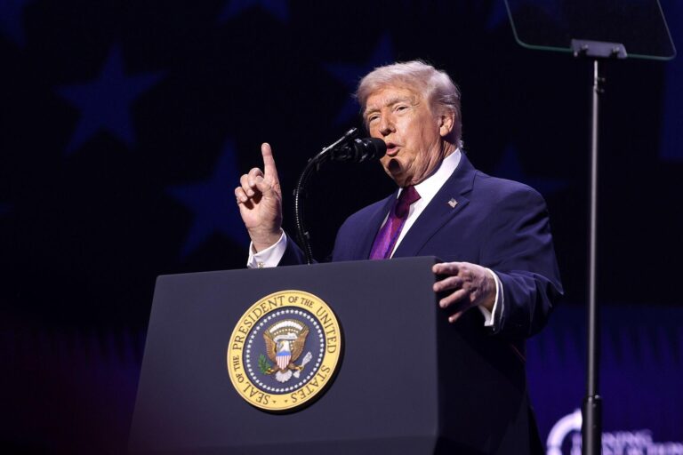 Informe Epstein: Donald Trump habla desde un podio presidencial durante un mitin en Estados Unidos