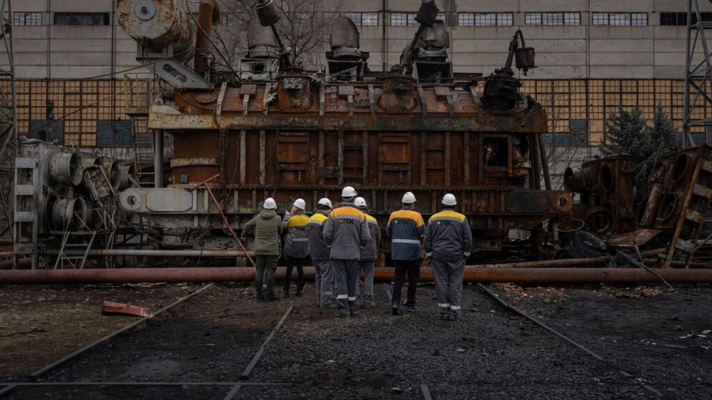 Ucranianos sin electricidad: trabajadores de la energética DTEK frente a un transformador destruido en una central eléctrica de Ucrania, en una imagen de archivo