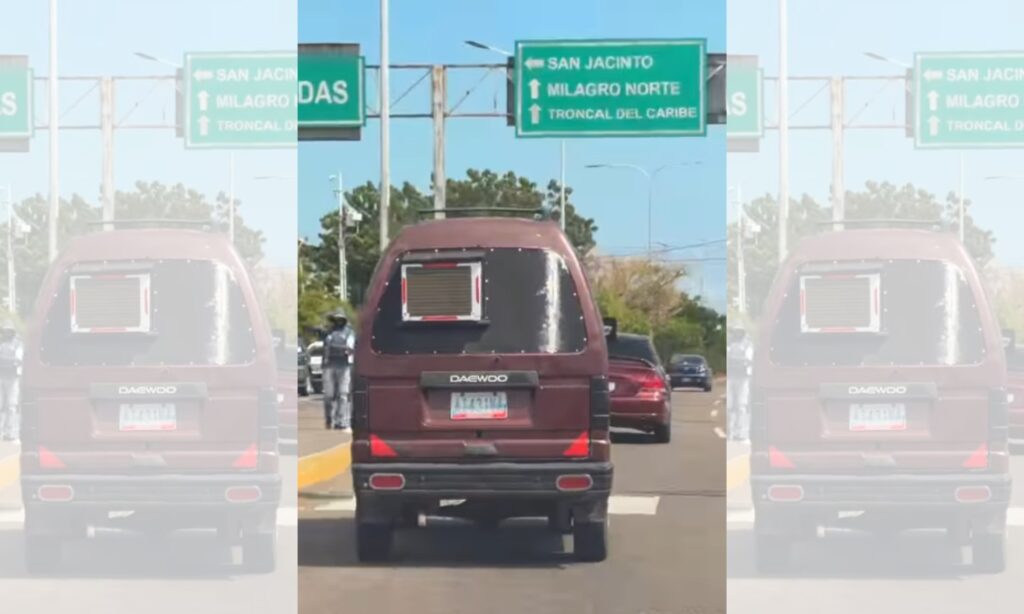 Van Daewoo Damas con un aire acondicionado de ventana instalado en el vidrio trasero, en una avenida de Maracaibo