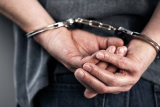 Venezolanos en Perú: manos esposadas de un detenido, en la nota sobre la banda de extorsión desarticulada en Puente Piedra, Lima