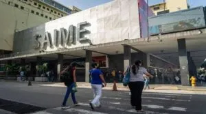 Verificación de datos Saime: fachada de una sede del Saime con ciudadanos cruzando la calle frente al organismo de identificación